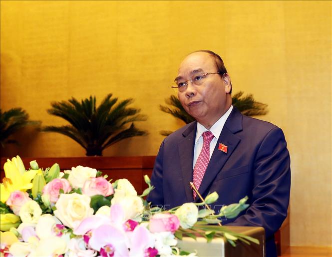 Trong ảnh: Thủ tướng Nguyễn Xuân Phúc đọc báo cáo của Chính phủ. Ảnh: Trọng Đức - TTXVN