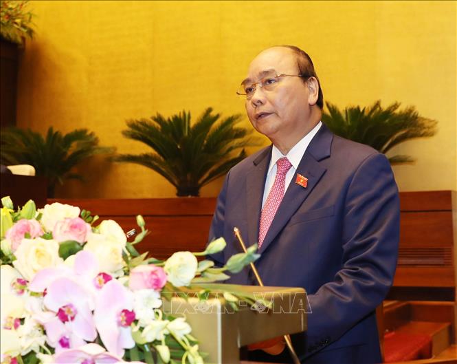 Trong ảnh: Thủ tướng Nguyễn Xuân Phúc đọc báo cáo của Chính phủ. Ảnh: Trọng Đức - TTXVN