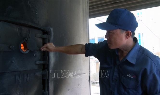 Trong ảnh: Lò hơi của nhà máy được đốt bằng trấu và mùn cưa. Ảnh: Xuân Triệu - TTXVN