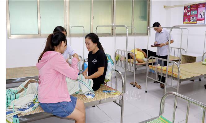 Trong ảnh: Công nhân Công ty Golden Victory Việt Nam điều trị tại phòng y tế của công ty. Ảnh: Nguyễn Lành - TTXVN