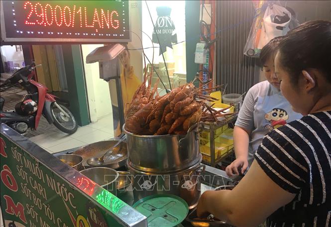 Trong ảnh: Đặc sản tôm càng xanh với các loại nước sốt trên đường Nguyễn Thượng Hiền, quận 3. Ảnh: Thanh Vũ - TTXVN

