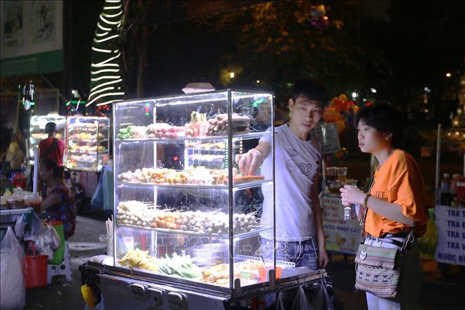 Photo: Various delicious fast foods are sold at street stands. VNA Photo: Thanh Vũ