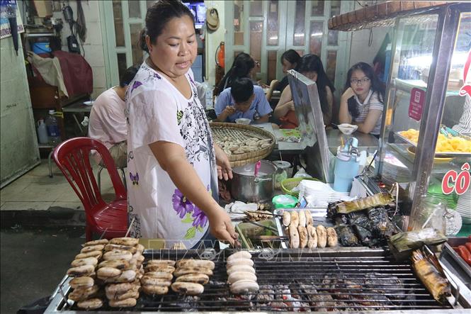 Photo: A stand selling grilled bananas with coconut milk - a popular food for young people - on Ho Thi Ky street. VNA Photo: Thanh Vũ