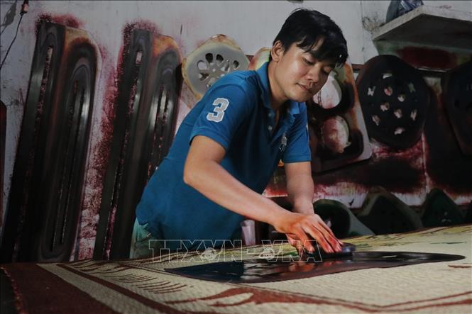 Trong ảnh: Người thợ làm công đoạn in họa tiết lên chiếu. Ảnh: Nam Thái - TTXVN