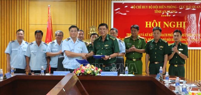 Đại tá Nguyễn Thượng Lễ, Chỉ huy trưởng Bộ Chỉ huy Bộ đội Biên phòng tỉnh An Giang (hàng đầu bên trái) và Cục trưởng Cục Hải quan An Giang Trần Quốc Hoàn (hàng đầu bên phải) ký hết quy chế phối hợp trong giai đoạn mới. Ảnh: Công Mạo-TTXVN