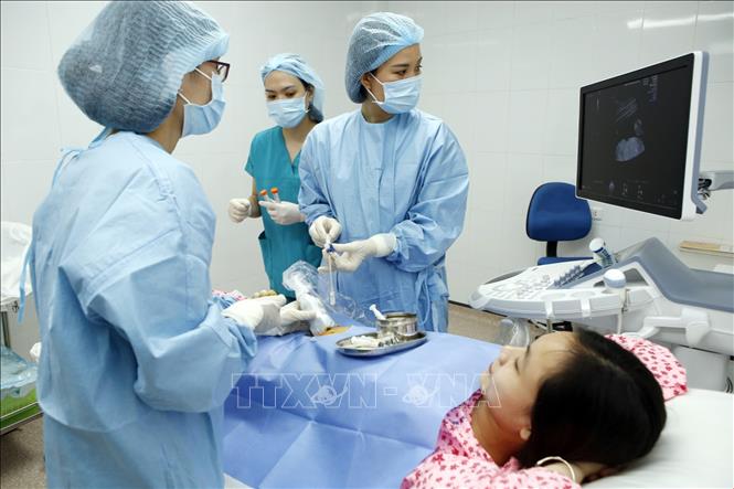 Trong ảnh: Cán bộ y tế siêu âm, chọc ối phân tích nhiễm sắc thể của thai nhi có nguy cơ cao tại Bệnh viện Phụ sản Hà Nội. Ảnh: Dương Ngọc – TTXVN