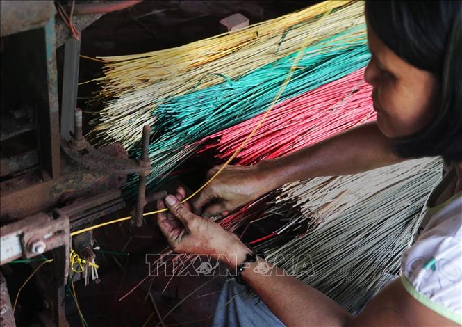 Photo: Weaving mats by machine in Long Dinh Village. VNA Photo: Nam Thái
