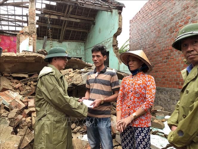 Trong ảnh: Ông Hồ Quốc Dũng, Chủ tịch UBND tỉnh Bình Định thăm hỏi, động viên và hỗ trợ bước đầu cho các hộ dân bị sập nhà ở xã Phước Thắng (huyện Tuy Phước) khắc phục hậu quả. Ảnh: Nguyên Linh - TTXVN