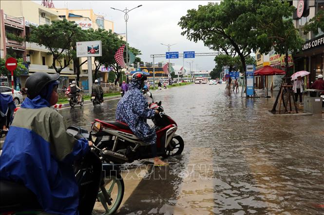 Trong ảnh: Người dân tìm đường đi tránh các khu bị ngập. Ảnh: Trần Lê Lâm - TTXVN 