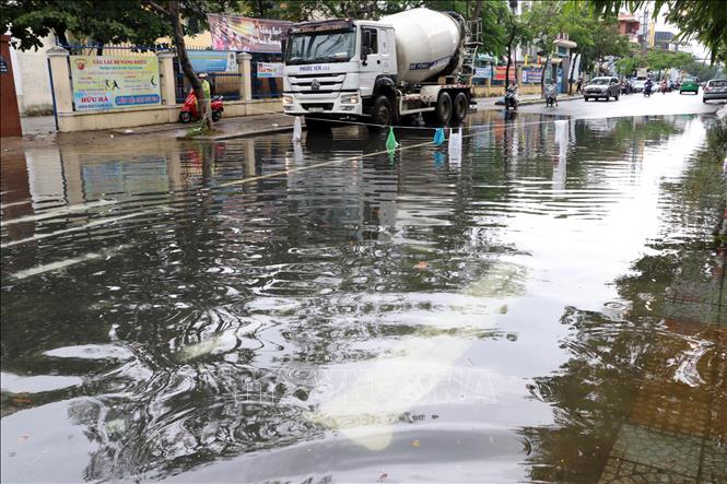 Trong ảnh: Khu vực đường Hà Huy Tập bị ngập sâu gần 0,5m người dân phải dùng dây chắn ngang để ngăn phương lưu đi vào khu vực nguy hiểm. Ảnh: Trần Lê Lâm - TTXVN 