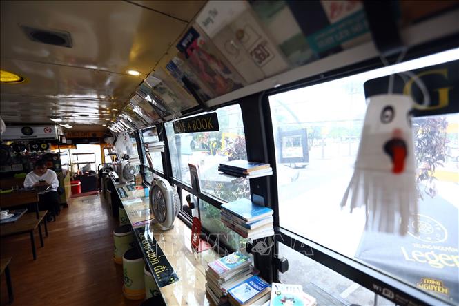 Trong ảnh: Bên trong chiếc xe buýt, toàn bộ ghế được thay thế bằng những chiếc bàn, ghế gỗ tận dụng từ lốp ô tô hỏng và thùng sơn bỏ đi. Ảnh: Huy Hùng - TTXVN