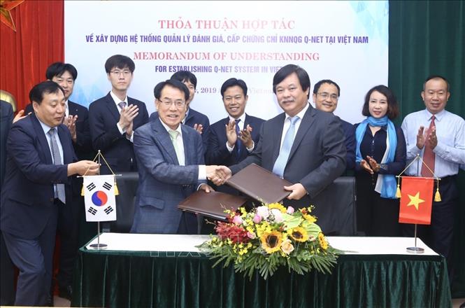 Trong ảnh: Ông Nguyễn Hồng Minh, Tổng cục trưởng Tổng cục Giáo dục nghề nghiệp và ông Mu Jang Byun, Phó chủ tịch Cơ quan Phát triển nguồn nhân lực Hàn Quốc (HRD) trao bản ký kết thoả thuận hợp tác. Ảnh: Minh Quyết - TTXVN