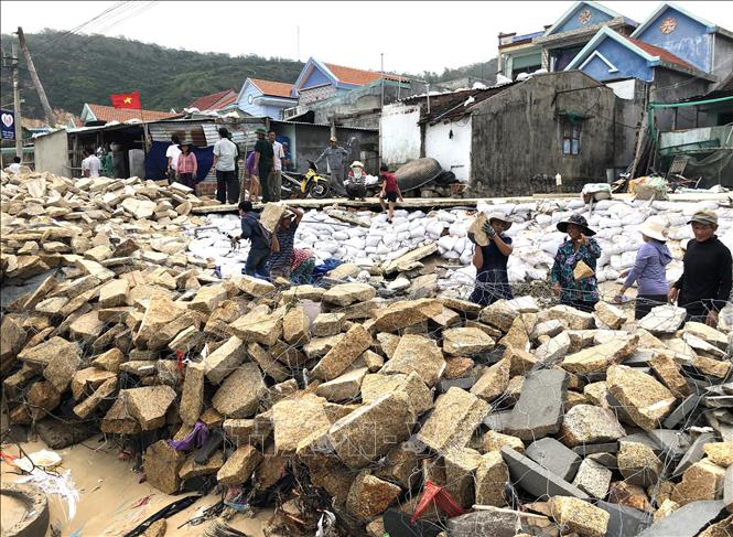 Người dân thôn Hải, xã Nhơn Hải, thành phố Quy Nhơn đắp kè đá ngăn sóng biển. Ảnh: Nguyên Linh - TTXVN