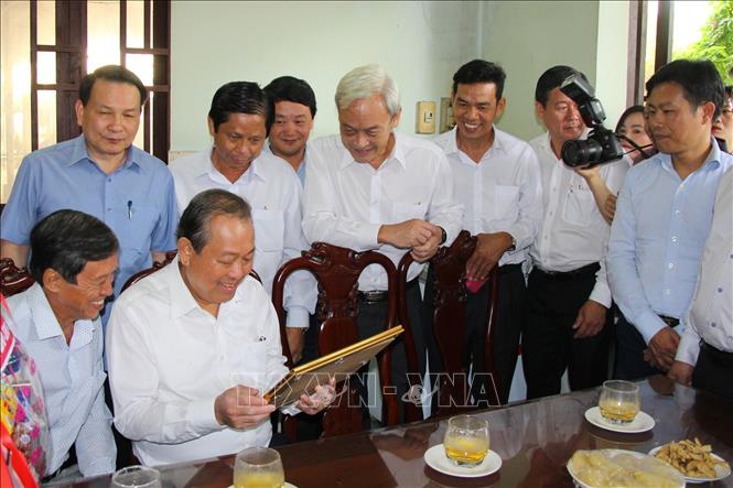 Trong ảnh: Phó Thủ tướng thường trực Trương Hòa Bình đến thăm, tặng quà các gia đình có công với cách mạng tại ấp Tân Triều. Ảnh: Lê Xuân-TTXVN