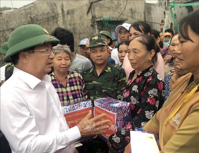 Trong ảnh: Phó Thủ tướng Trịnh Đình Dũng tặng quà cho người dân bị sập nhà do bão số 5 ở xã Nhơn Hải, TP Quy Nhơn, tỉnh Bình Định. Ảnh: Nguyên Linh - TTXVN