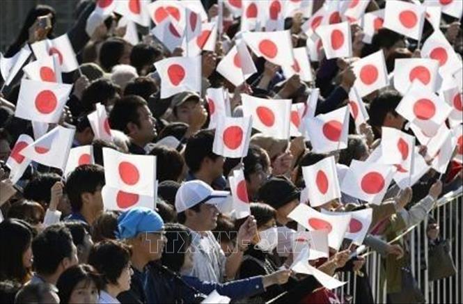 Trong ảnh: Người dân Nhật Bản vẫy cờ chào đón Nhật hoàng Naruhito  và Hoàng hậu Masako tại lễ diễu hành ở Tokyo, Nhật Bản, ngày 10/11/2019.  Ảnh:Kyodo/TTXVN