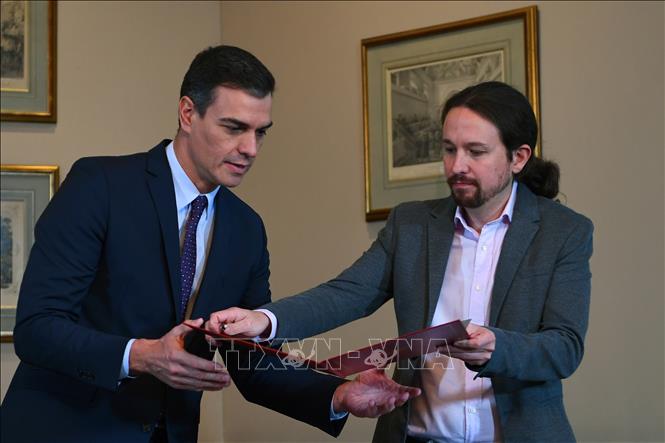Trong ảnh: Thủ tướng tạm quyền Tây Ban Nha Pedro Sanchez (trái) và lãnh đạo đảng Unidas Podemos, ông Pablo Iglesias trao đổi thỏa thuận sơ bộ về thành lập Chính phủ liên minh tại lễ ký ở thủ đô Madrid ngày 12/11/2019. Ảnh: AFP/TTXVN