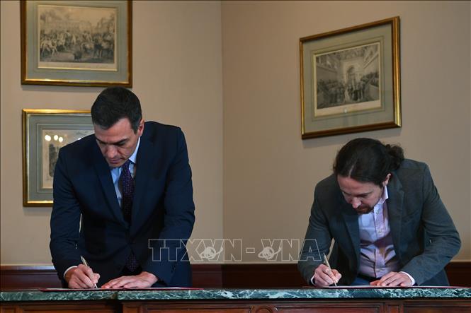Trong ảnh: Thủ tướng tạm quyền Tây Ban Nha Pedro Sanchez (trái) và lãnh đạo đảng Unidas Podemos, ông Pablo Iglesias, ký thỏa thuận sơ bộ về thành lập Chính phủ liên minh tại thủ đô Madrid ngày 12/11/2019. Ảnh: AFP/TTXVN