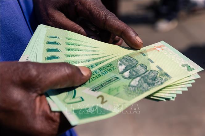 Trong ảnh: Người dân nhận tiền giấy mới có mệnh giá 2 ZWD từ một ngân hàng ở Harare, Zimbabwe ngày 12/11/2019. Ảnh: AFP/TTXVN