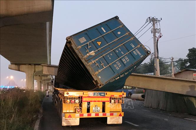 Trong ảnh: Xe container bị dầm bê-tông đè lên nóc. Ảnh: TTXVN phát