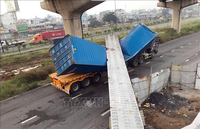 Trong ảnh: Xe container bị dầm bê-tông đè lên dập móp. Ảnh: TTXVN phát