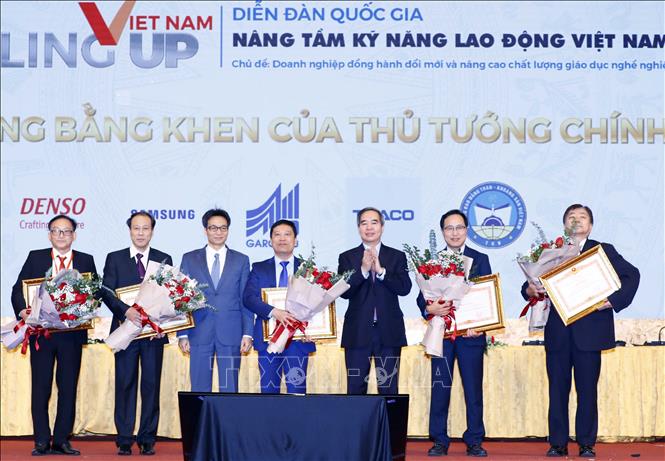 Trong ảnh: Trưởng ban Kinh tế Trung ương Nguyễn Văn Bình và Phó Thủ tướng Vũ Đức Đam trao Bằng khen Thủ tướng Chính phủ tặng các đơn vị có thành tích trong kết nối doanh nghiệp và nhà trường. Ảnh: Thống Nhất - TTXVN 
