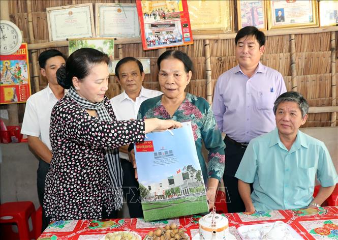 Trong ảnh: Chủ tịch Quốc hội Nguyễn Thị Kim Ngân thăm và tặng quà bà Kim Thị Sông ở ấp Ba Tục A, xã Thanh Sơn huyện Trà Cú trước đây bị địch bắt tù đầy. Ảnh: Trọng Đức - TTXVN