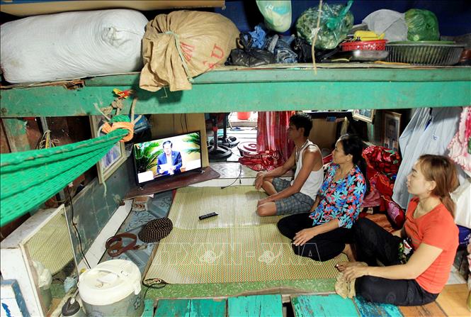 Trong ảnh: Tuy nghèo, nhưng người dân xóm chài luôn tranh thủ theo dõi chương trình họp quốc hội để hiểu biết thêm về pháp luật cũng như chính sách của Nhà nước. Ảnh: An Đăng - TTXVN