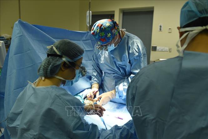 Trong ảnh: Bác sỹ Stéphane Guero (giữa) thực hiện phẫu thuật dị dạng ngón tay cho bệnh nhi có hoàn cảnh khó khăn. Ảnh: TTXVN phát
