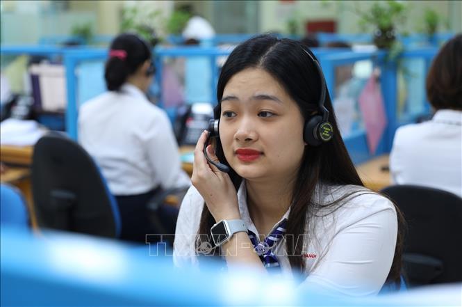 Trong ảnh: Nhân viên Trung tâm chăm sóc khách hàng Tổng Công ty Điện lực Thành phố Hà Nội trong ca trực. Ảnh: Ngọc Hà - TTXVN