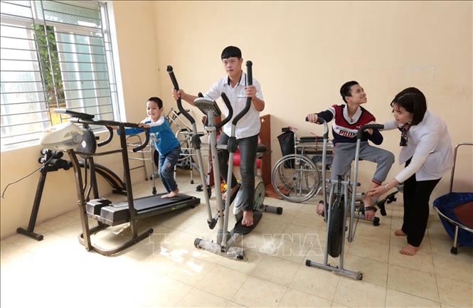 Trong ảnh: Hướng dẫn tập phục hồi chức năng cho học sinh tại trường Phục hồi chức năng và Dạy nghề cho người khuyết tật Khoái Châu. Ảnh: Anh Tuấn – TTXVN