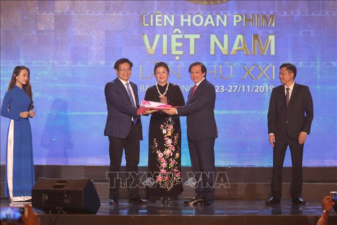 Thứ trưởng Bộ Văn hóa, Thể thao và Du lịch Tạ Quang Đông trao cờ cho Giám đốc Sở Văn hóa, Thể thao tỉnh Thừa Thiên - Huế, đại diện đơn vị địa điểm đăng cai Liên hoan Phim Việt Nam lần thứ 22 năm 2021. Ảnh: Huỳnh Ngọc Sơn-TTXVN