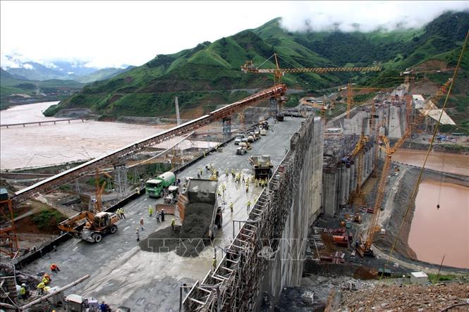 Trong ảnh: Các đơn vị thi công của Tổng công ty Xây dựng Trường Sơn-Binh đoàn 12, Tổng công ty Licogi và Tổng công ty Sông Đà tiến hành đổ bê-tông đầm lăn trên mặt đập của công trình nhà máy thủy điện Sơn La (tháng 7/2009). Ảnh: Huy Hùng – TTXVN