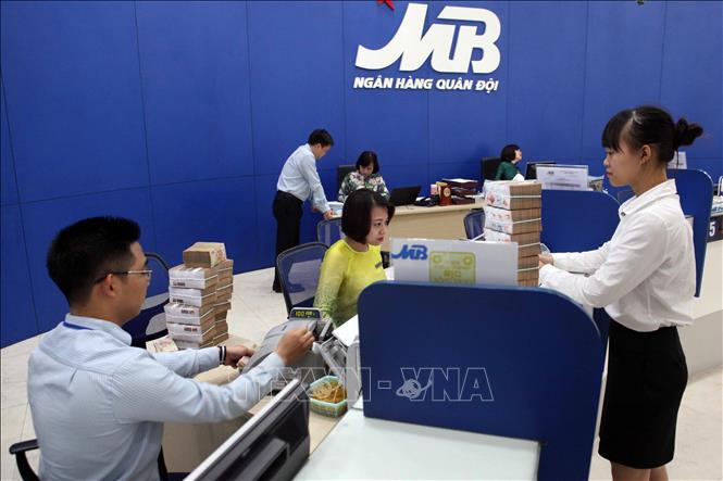 Ngân hàng TMCP Quân đội (MB) đã đưa ra nhiều gói tín dụng ưu đãi dành cho khách hàng là doanh nghiệp và cá nhân phục vụ sản xuất và tiêu dùng; tăng cường kiểm soát vốn vay để đảm bảo an toàn cho sự tăng trưởng của ngân hàng và an toàn cho doanh nghiệp. Trong ảnh: Khách hàng giao dịch tại Hội sở chính Ngân hàng TMCP Quân đội (MB) ở Hà Nội. Ảnh: Trần Việt - TTXVN