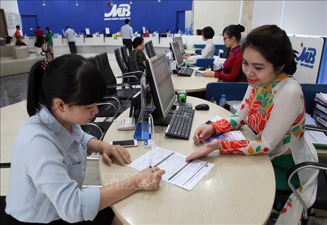 Ngân hàng TMCP Quân đội (MB) đã đưa ra nhiều gói tín dụng ưu đãi dành cho khách hàng là doanh nghiệp và cá nhân phục vụ sản xuất và tiêu dùng; tăng cường kiểm soát vốn vay để đảm bảo an toàn cho sự tăng trưởng của ngân hàng và an toàn cho doanh nghiệp. Trong ảnh: Khách hàng giao dịch tại Hội sở chính Ngân hàng TMCP Quân đội (MB) ở Hà Nội. Ảnh: Trần Việt - TTXVN