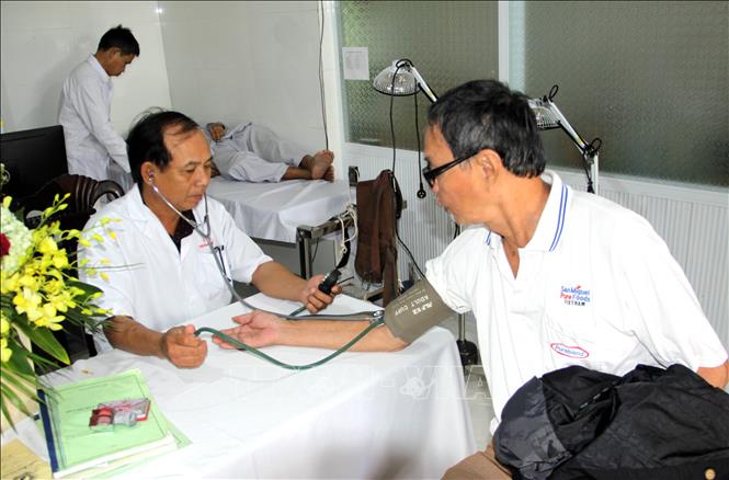 Trong ảnh: Các lương y khám chữa  bệnh cho bệnh nhân nghèo. Ảnh: Trịnh Bang Nhiệm - TTXVN