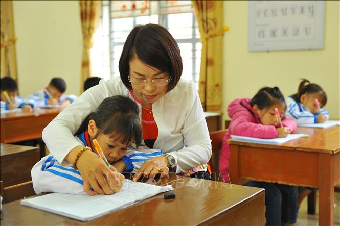 Trong ảnh: Cô giáo Nguyễn Thị Hằng hướng dẫn học sinh giờ tập viết. Ảnh: Minh Đức - TTXVN