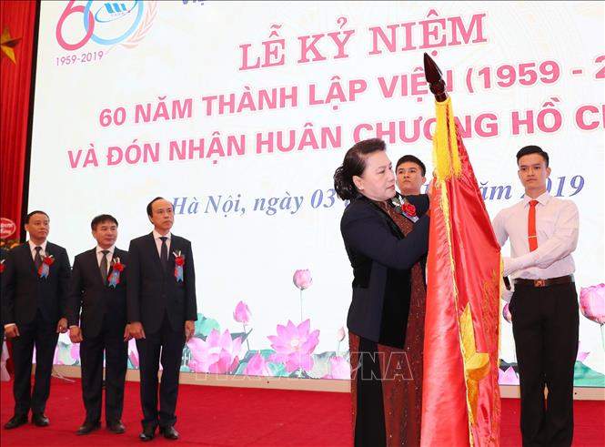 Trong ảnh: Chủ tịch Quốc hội Nguyễn Thị Kim Ngân gắn Huân chương Hồ Chí Minh lên cờ truyền thống của Viện khoa học Thủy lợi Việt Nam. Ảnh: Trọng Đức - TTXVN