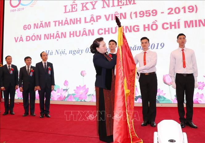 Trong ảnh: Chủ tịch Quốc hội Nguyễn Thị Kim Ngân gắn Huân chương Hồ Chí Minh lên cờ truyền thống của Viện khoa học Thủy lợi Việt Nam. Ảnh: Trọng Đức - TTXVN