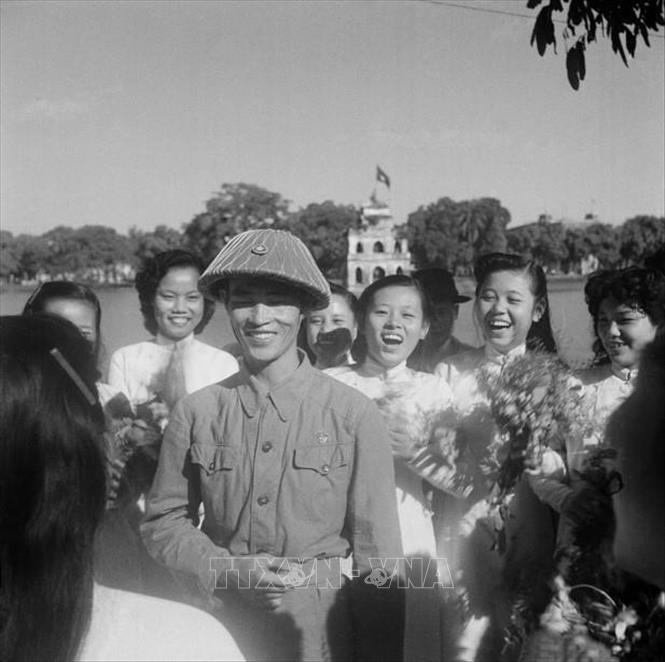 7. “Vì nhân dân mà chiến đấu” là một nét đặc trưng nổi bật trong bản chất, truyền thống vẻ vang của QĐND Việt Nam. Đặc trưng “vì nhân dân mà chiến đấu” của QĐND được thể hiện ở mục tiêu, lý tưởng chiến đấu vì độc lập, tự do của Tổ quốc, vì chủ nghĩa xã hội, vì ấm no, tự do, hạnh phúc của nhân dân. Trong ảnh: Thiếu tướng Vương Thừa Vũ, Tư lệnh Đại đoàn 308, Chủ tịch Ủy ban Quân chính Thành phố giữa vòng vây của các nữ sinh trường Trưng Vương tặng hoa chúc mừng bên hồ Hoàn Kiếm trong ngày giải phóng Thủ đô 10/10/1954. Ảnh: Tư liệu TTXVN