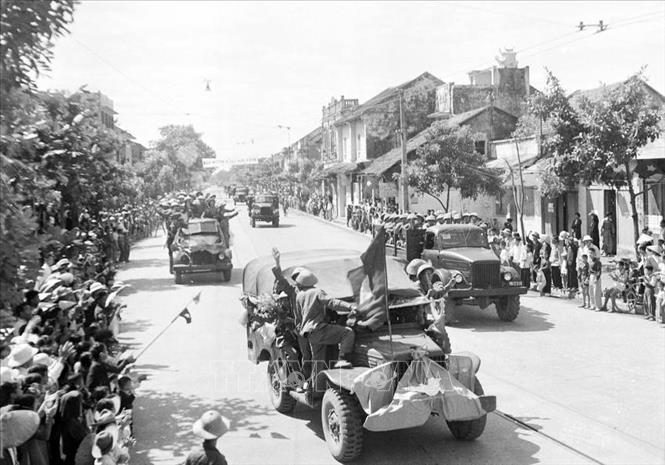 7. “Vì nhân dân mà chiến đấu” là một nét đặc trưng nổi bật trong bản chất, truyền thống vẻ vang của QĐND Việt Nam. Đặc trưng “vì nhân dân mà chiến đấu” của QĐND được thể hiện ở mục tiêu, lý tưởng chiến đấu vì độc lập, tự do của Tổ quốc, vì chủ nghĩa xã hội, vì ấm no, tự do, hạnh phúc của nhân dân. Trong ảnh: Sáng 10/10/1954, các đơn vị của Đại đoàn Quân Tiên Phong-Sư đoàn 308 chia làm nhiều cánh mở cuộc hành quân lịch sử tiến vào Hà Nội trong rừng cờ hoa cùng niềm vui hân hoan của hai mươi vạn người dân Thủ đô tràn ra đường chào đón đoàn quân chiến thắng. Ảnh: Tư liệu TTXVN