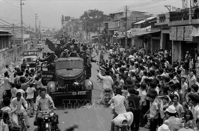 18. Năm 1975, khi thời cơ chiến lược xuất hiện, nhờ có nhân dân tích cực chuẩn bị chiến trường, phối hợp chiến đấu, quân đội có điều kiện tiến công thần tốc, thực hiện trận quyết chiến chiến lược trong cuộc Tổng tấn công và nổi dậy mùa Xuân 1975 mà đỉnh cao là chiến dịch Hồ Chí Minh lịch sử, giải phóng hoàn toàn miền Nam, thống nhất đất nước. Trong ảnh: Nhân dân Sài Gòn đổ ra đường, nồng nhiệt chào đón Quân giải phóng tiến vào thành phố. Ảnh: Hứa Kiểm - TTXVN