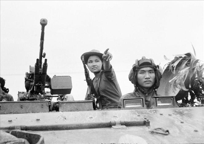 18. Năm 1975, khi thời cơ chiến lược xuất hiện, nhờ có nhân dân tích cực chuẩn bị chiến trường, phối hợp chiến đấu, quân đội có điều kiện tiến công thần tốc, thực hiện trận quyết chiến chiến lược trong cuộc Tổng tấn công và nổi dậy mùa Xuân 1975 mà đỉnh cao là chiến dịch Hồ Chí Minh lịch sử, giải phóng hoàn toàn miền Nam, thống nhất đất nước. Trong ảnh: Lực lượng xe tăng Sư đoàn 10 (Quân đoàn 3) được nữ chiến sĩ biệt động Nguyễn Trung Kiên (Cao Thị Nhíp) dẫn đường, đánh chiếm sân bay Tân Sơn Nhất, ngày 30/4/1975. Ảnh: TTXVN
