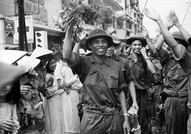 18. Năm 1975, khi thời cơ chiến lược xuất hiện, nhờ có nhân dân tích cực chuẩn bị chiến trường, phối hợp chiến đấu, quân đội có điều kiện tiến công thần tốc, thực hiện trận quyết chiến chiến lược trong cuộc Tổng tấn công và nổi dậy mùa Xuân 1975 mà đỉnh cao là chiến dịch Hồ Chí Minh lịch sử, giải phóng hoàn toàn miền Nam, thống nhất đất nước. Trong ảnh: Quân giải phóng tiến vào thành phố Đà Nẵng trong sự chào đón hân hoan của các tầng lớp nhân dân. Ảnh: Quang Thành - TTXVN