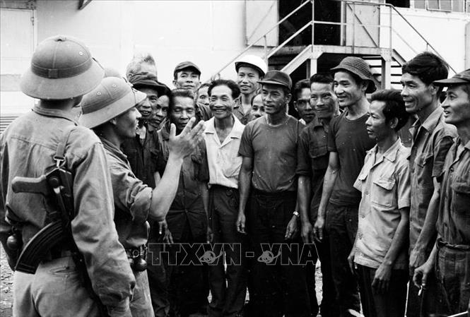 18. Năm 1975, khi thời cơ chiến lược xuất hiện, nhờ có nhân dân tích cực chuẩn bị chiến trường, phối hợp chiến đấu, quân đội có điều kiện tiến công thần tốc, thực hiện trận quyết chiến chiến lược trong cuộc Tổng tấn công và nổi dậy mùa Xuân 1975 mà đỉnh cao là chiến dịch Hồ Chí Minh lịch sử, giải phóng hoàn toàn miền Nam, thống nhất đất nước. Trong ảnh: Công nhân nhà máy dệt Đà Nẵng chào đón các chiến sĩ quân giải phóng. Ảnh: Vũ Tạo - TTXVN