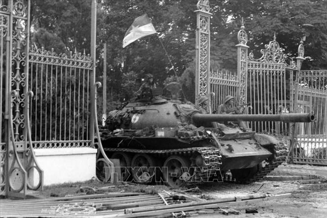 18. Năm 1975, khi thời cơ chiến lược xuất hiện, nhờ có nhân dân tích cực chuẩn bị chiến trường, phối hợp chiến đấu, quân đội có điều kiện tiến công thần tốc, thực hiện trận quyết chiến chiến lược trong cuộc Tổng tấn công và nổi dậy mùa Xuân 1975 mà đỉnh cao là chiến dịch Hồ Chí Minh lịch sử, giải phóng hoàn toàn miền Nam, thống nhất đất nước. Trong ảnh: Xe tăng của Lữ đoàn tăng – thiết giáp 203, Sư đoàn 304, Quân đoàn 2 tiến vào Dinh Độc Lập, trưa 30/4/1975. Ảnh: Trần Mai Hưởng - TTXVN