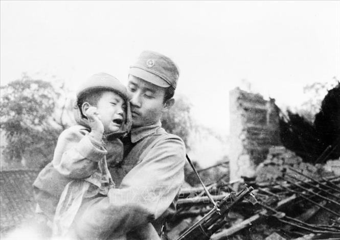 19. “Vì nhân dân mà chiến đấu” là nét đặc trưng nổi bật trong bản chất, truyền thống vẻ vang của QĐND Việt Nam, thể hiện ở mục tiêu, lý tưởng chiến đấu vì độc lập, tự do của Tổ quốc, vì chủ nghĩa xã hội, vì ấm no, tự do, hạnh phúc của nhân dân. Trong ảnh: Chiến sĩ bộ đội biên phòng Ngô Duy Nhung cứu sống kịp thời cháu bé này từ trong đống đổ nát, trong cuộc chiến đấu bảo vệ biên giới phía Bắc Tổ quốc, tháng 2/1979. Ảnh: Ngô Đình Phước - TTXVN