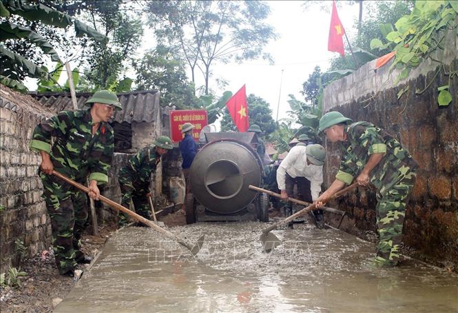 22. Quân đội tích cực tham gia phong trào xây dựng nông thôn mới một cách hiệu quả, thiết thực, phù hợp với đặc điểm, tổ chức, chức năng, nhiệm vụ của quân đội. Trong ảnh: Cán bộ, chiến sĩ Lữ đoàn pháo binh 241 đổ bê tông đường làng, ngõ xóm tại thôn Xanh, xã Quỳnh Lưu, huyện Nho Quan, tỉnh Ninh Bình. Ảnh: Trọng Đức - TTXVN