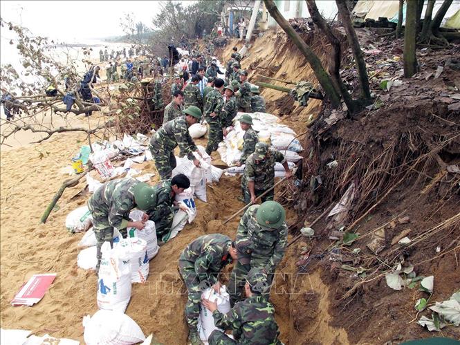 23. QĐND tham gia phòng, chống thiên tai, cứu hộ, cứu nạn, khắc phục hậu quả chiến tranh… Trong ảnh: Lực lượng bộ đội cùng nhân dân tham gia đắp kè chắn sóng biển xâm thực. Ảnh: Thanh Long - TTXVN