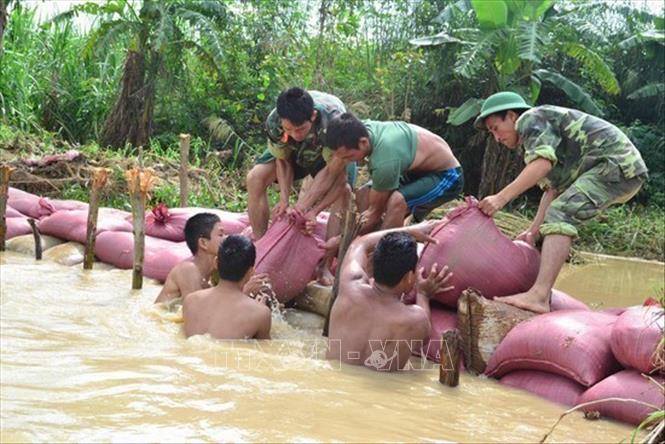 23. QĐND tham gia phòng, chống thiên tai, cứu hộ, cứu nạn, khắc phục hậu quả chiến tranh… Trong ảnh: Chiến sĩ Lữ đoàn Phòng không 573 gia cố đoạn đê bị hư tại thôn Thượng Giang 2, xã Tây Giang, huyện Tây Sơn, tỉnh Bình Định trong trận lũ lớn tháng 11/2013. Ảnh: TTXVN phát